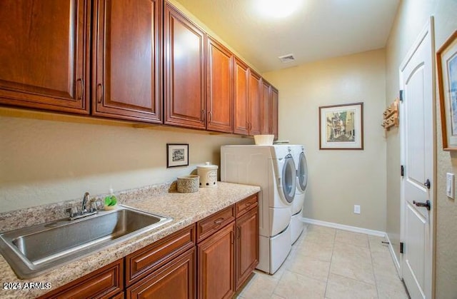 laundry area featuring independent washer and dryer, cabinets, light tile floors, and sink