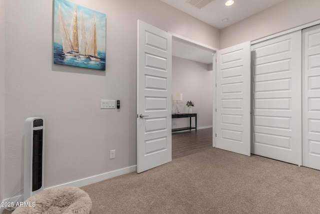 carpeted bedroom with a closet and heating unit