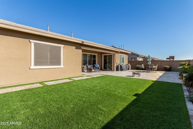 back of property with a patio area and a yard