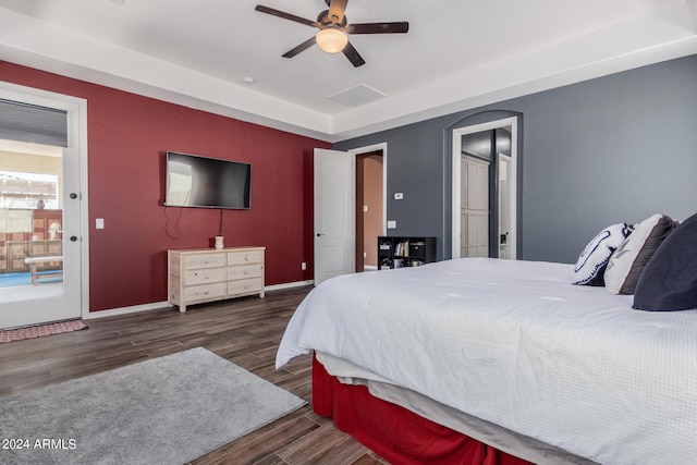 bedroom with dark hardwood / wood-style flooring, ceiling fan, and access to exterior