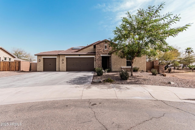 view of front facade featuring an attached garage, solar panels, fence, driveway, and stucco siding