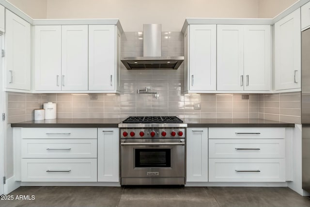 kitchen featuring premium range, backsplash, white cabinets, and wall chimney exhaust hood