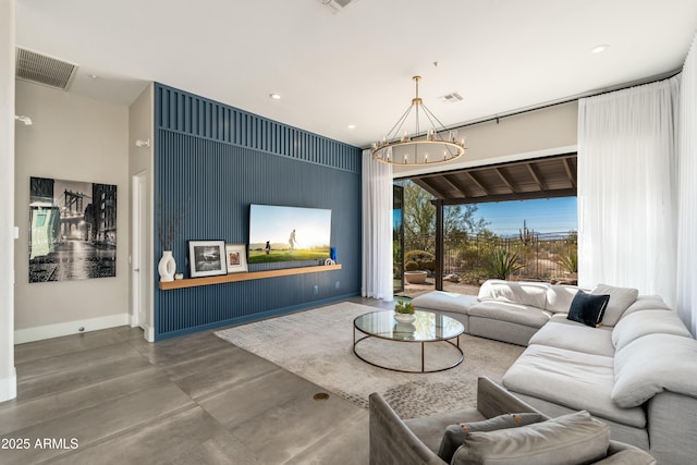 living room with concrete flooring and an inviting chandelier