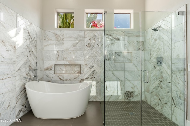 bathroom with independent shower and bath, tile patterned flooring, and tile walls