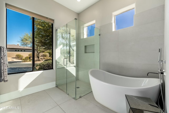 bathroom featuring a healthy amount of sunlight, shower with separate bathtub, and tile patterned flooring