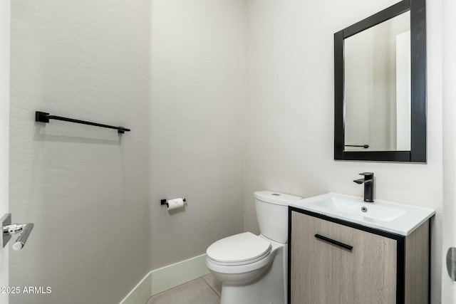 bathroom featuring vanity, tile patterned flooring, and toilet