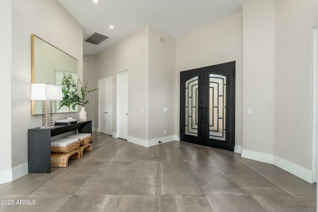 foyer with a towering ceiling and french doors