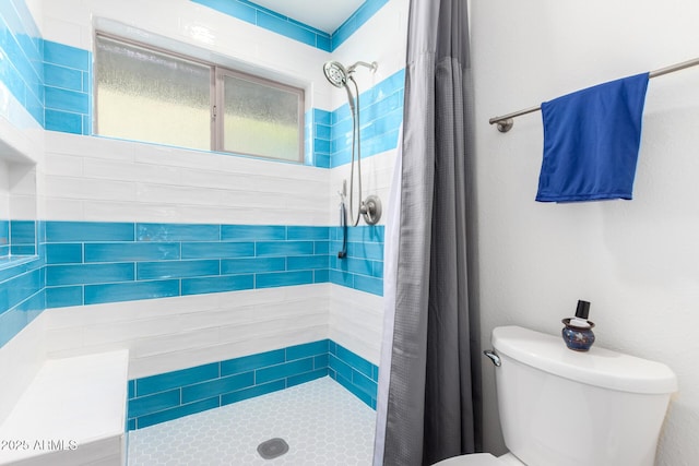 bathroom with a shower stall and toilet