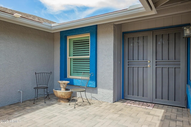 property entrance featuring a patio and stucco siding