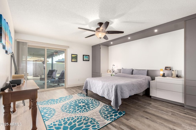 bedroom with ceiling fan, light wood-style floors, a textured ceiling, access to exterior, and baseboards