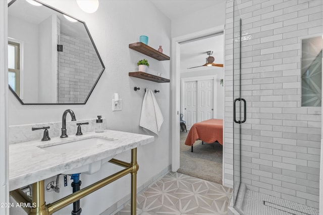 bathroom with tile patterned flooring, ceiling fan, a shower with shower door, and sink