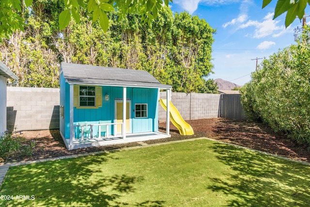 view of outbuilding with a lawn and a playground