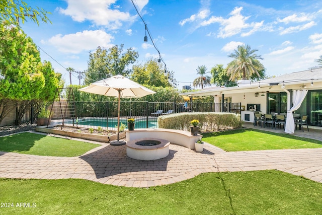 view of patio with a fire pit and a fenced in pool