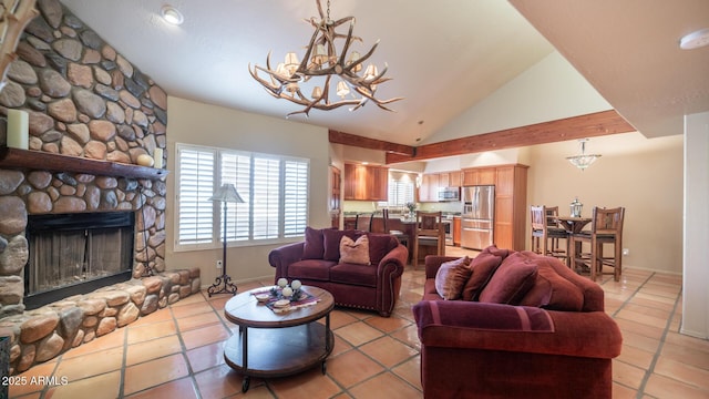 living room with high vaulted ceiling, light tile patterned floors, a stone fireplace, and a chandelier