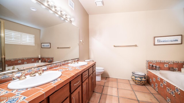 bathroom with tiled tub, toilet, tile patterned floors, and vanity