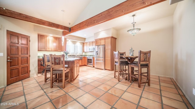 kitchen with pendant lighting, appliances with stainless steel finishes, light tile patterned floors, light stone countertops, and a kitchen island