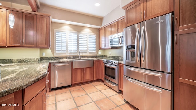 kitchen featuring light tile patterned flooring, appliances with stainless steel finishes, sink, and dark stone countertops