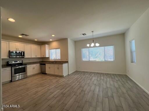 kitchen with appliances with stainless steel finishes, light wood-type flooring, and plenty of natural light