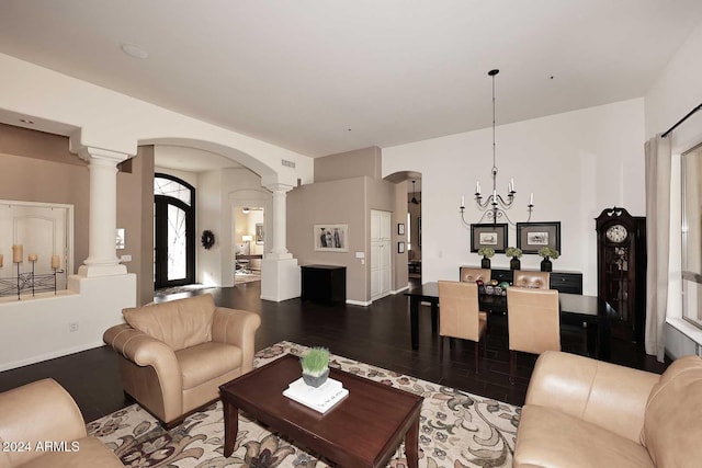 living room featuring a chandelier, wood-type flooring, and decorative columns