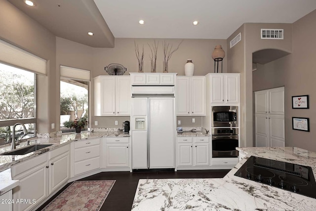 kitchen featuring white cabinetry, sink, light stone countertops, and appliances with stainless steel finishes