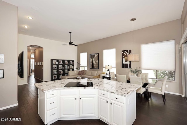 kitchen featuring light stone countertops, ceiling fan, dark hardwood / wood-style flooring, pendant lighting, and white cabinets