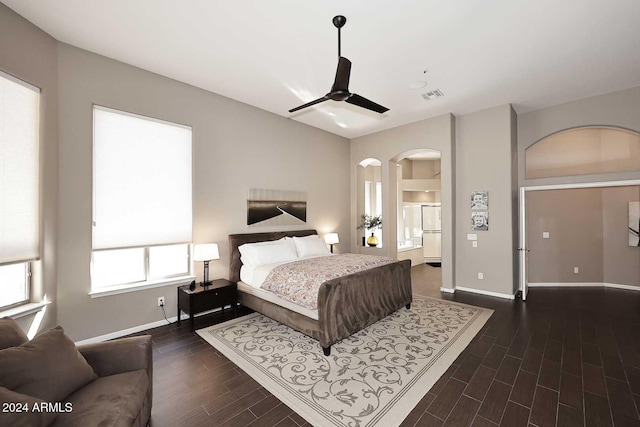 bedroom with dark hardwood / wood-style floors, ceiling fan, and ensuite bathroom