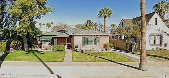 bungalow with fence, concrete driveway, and a front yard