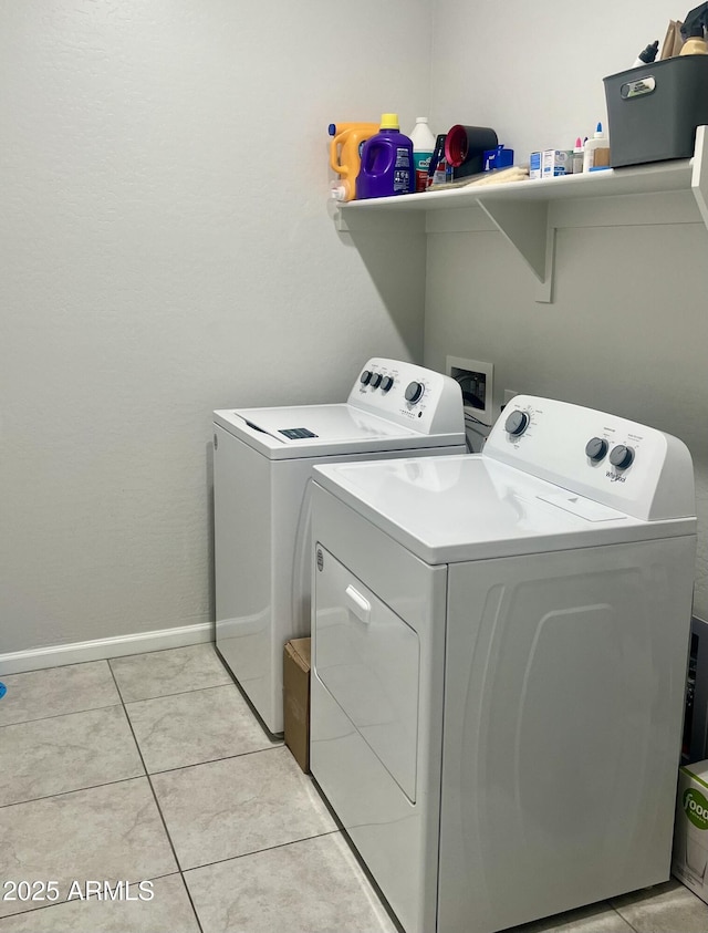 laundry room with light tile patterned floors and washing machine and clothes dryer