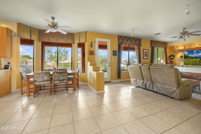 tiled living room with ceiling fan and a wealth of natural light