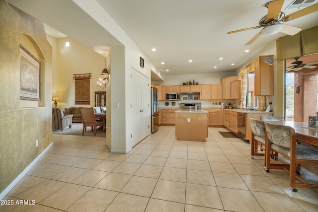 kitchen featuring light brown cabinetry, appliances with stainless steel finishes, a center island, and light tile patterned floors