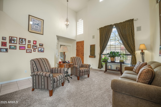 tiled living room featuring a towering ceiling and a chandelier