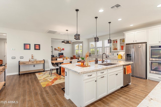 20684 W Meadowbrook Ave, Buckeye, AZ 85396 - kitchen featuring stainless steel appliances, dark wood-style flooring, recessed lighting, white cabinetry, and a center island with sink