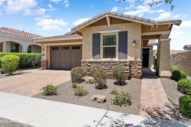 20684 W Meadowbrook Ave, Buckeye, AZ 85396 - view of front of home with an attached garage, stucco siding, decorative driveway, and stone siding