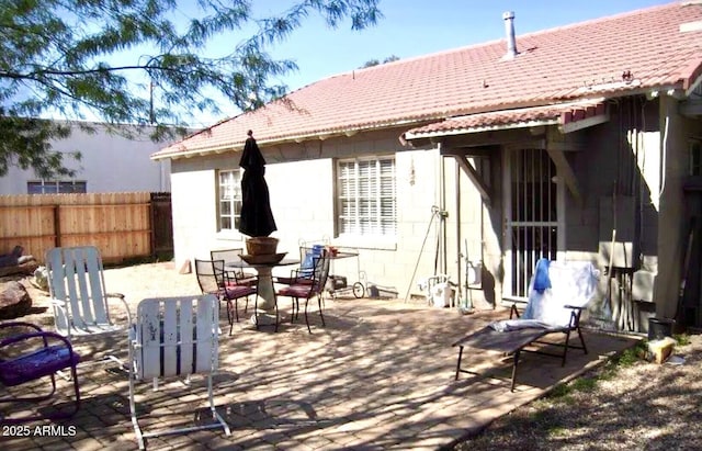 1837 W Roma Ave, Phoenix, AZ 85015 - rear view of house featuring outdoor dining space, a patio, concrete block siding, a tiled roof, and fence