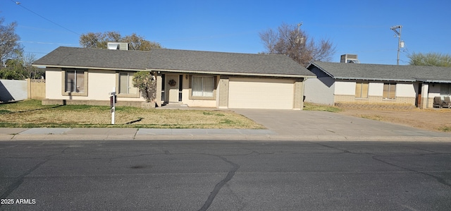 ranch-style house with an attached garage, fence, driveway, and roof with shingles