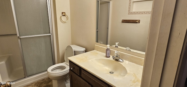 bathroom featuring vanity, toilet, and a shower stall