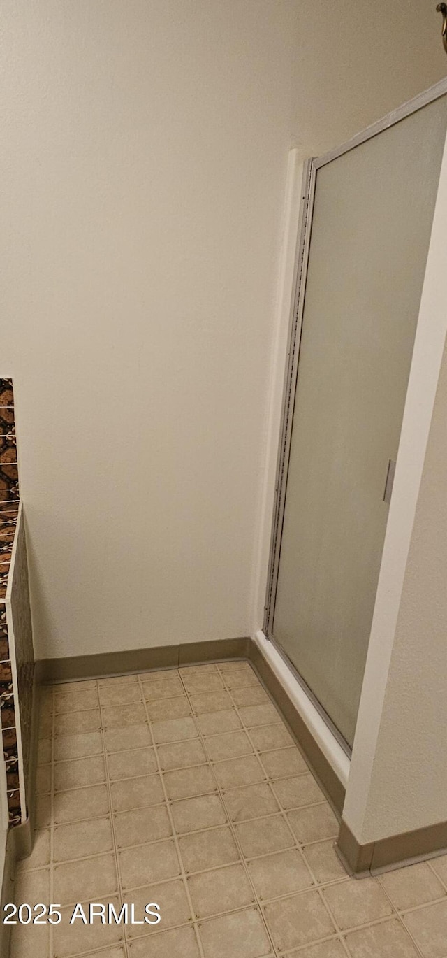 bathroom featuring baseboards and a stall shower