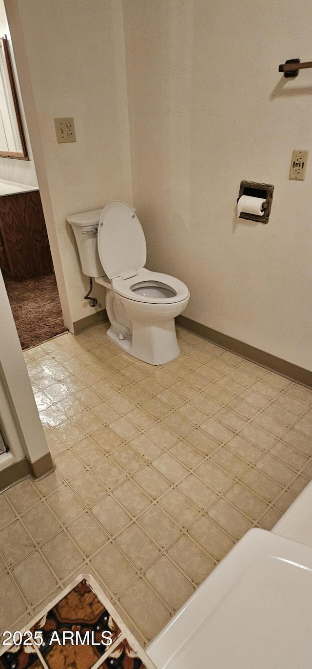 bathroom featuring tile patterned floors, baseboards, and toilet