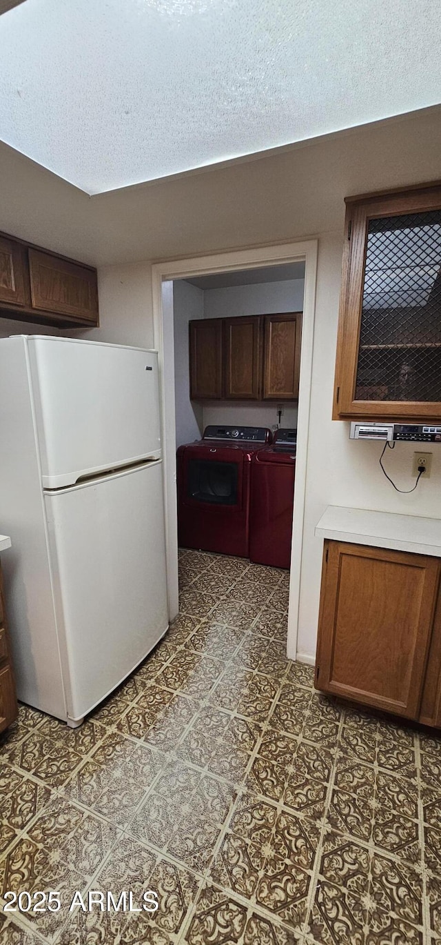 kitchen with washer and dryer and freestanding refrigerator