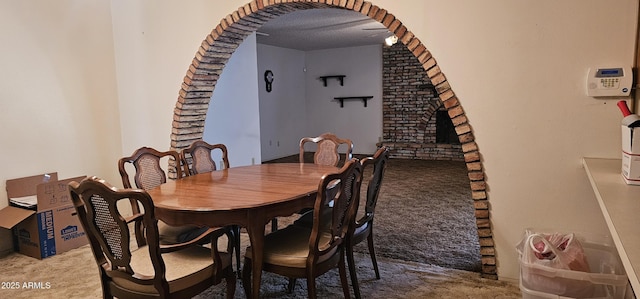 carpeted dining room with arched walkways