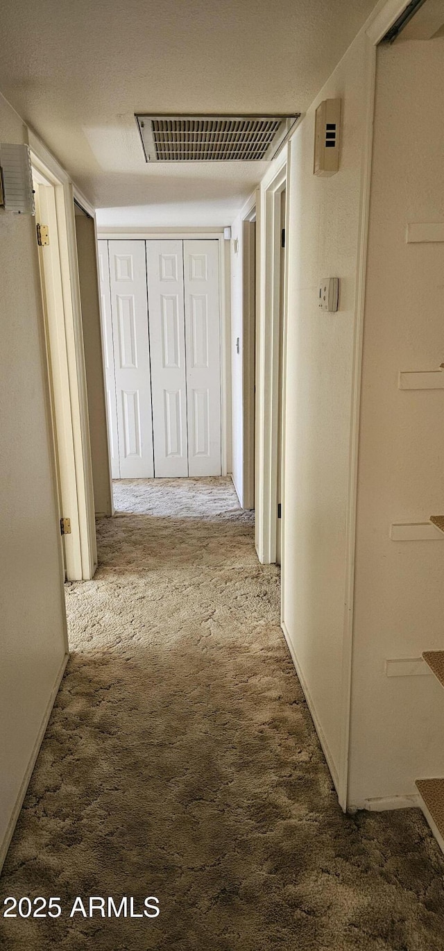 hallway with carpet flooring and visible vents