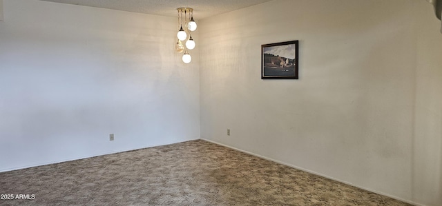 spare room featuring carpet flooring and a textured ceiling