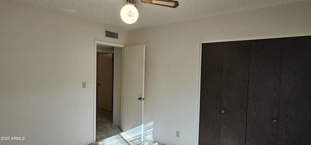 unfurnished bedroom featuring visible vents, a textured ceiling, and a closet