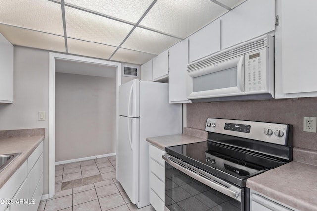 kitchen featuring white cabinetry, light tile patterned floors, and white appliances