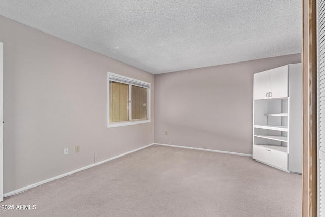 carpeted spare room featuring a textured ceiling