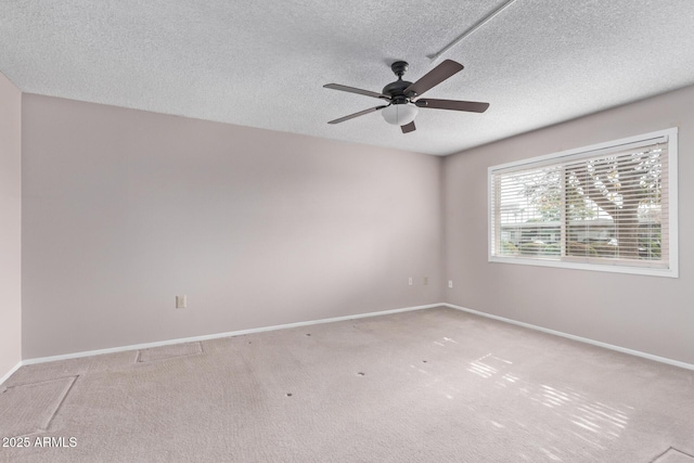 carpeted empty room featuring ceiling fan and a textured ceiling