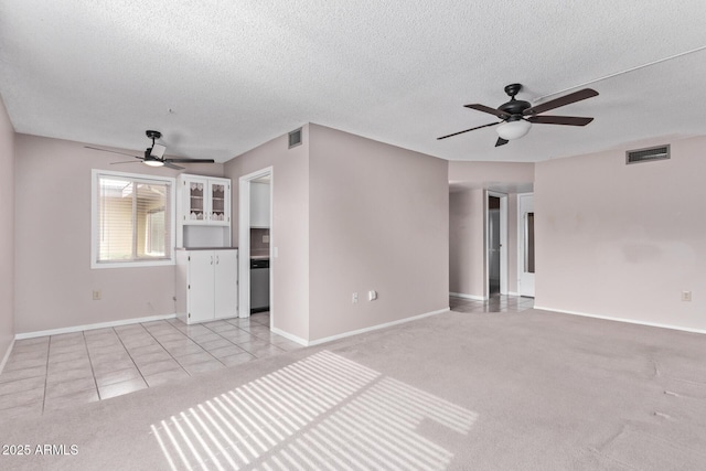 unfurnished living room featuring ceiling fan, a textured ceiling, and light tile patterned floors