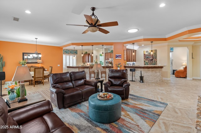 living room with bar, ceiling fan with notable chandelier, and ornamental molding