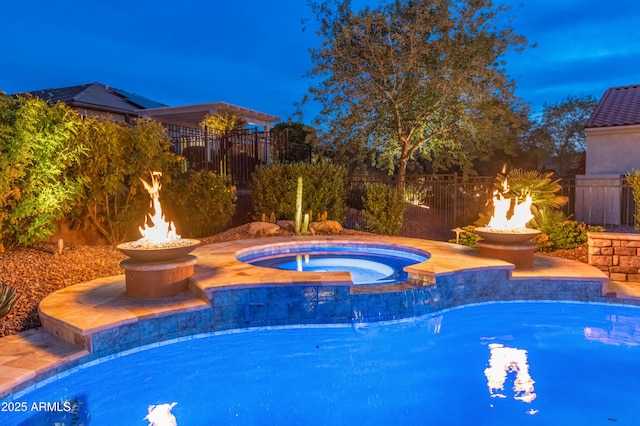 view of swimming pool featuring an in ground hot tub and an outdoor fire pit