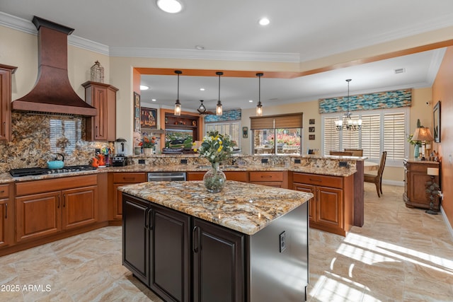 kitchen featuring premium range hood, stainless steel gas cooktop, light stone counters, kitchen peninsula, and pendant lighting